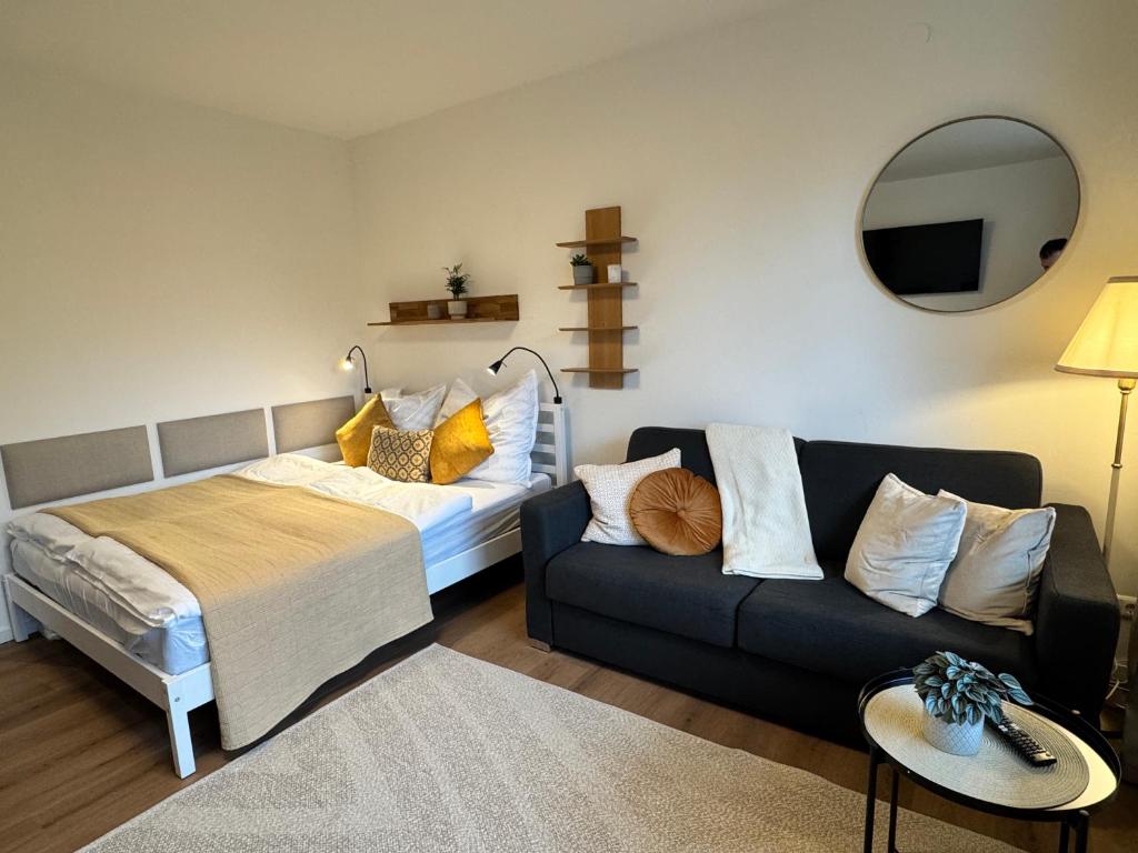 a living room with a bed and a couch at LakeCity Apartment in Klagenfurt