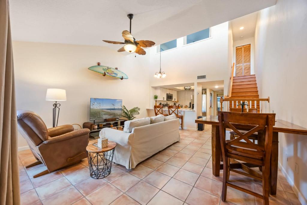 a living room with a couch and a table at Beach Townhome Steps from Downtown Cocoa Beach in Cocoa Beach