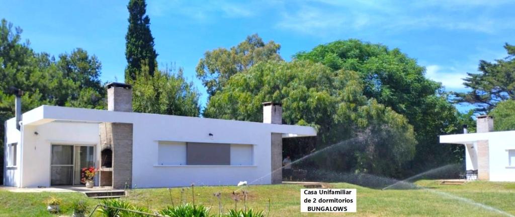 una casa con un rociador en un patio en Senda Marina Aparto Hotel, en Punta del Este