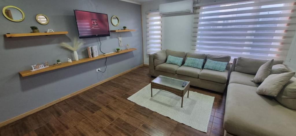 a living room with a couch and a tv at Casa mirador de volcanes, 6 personas in Llanquihue