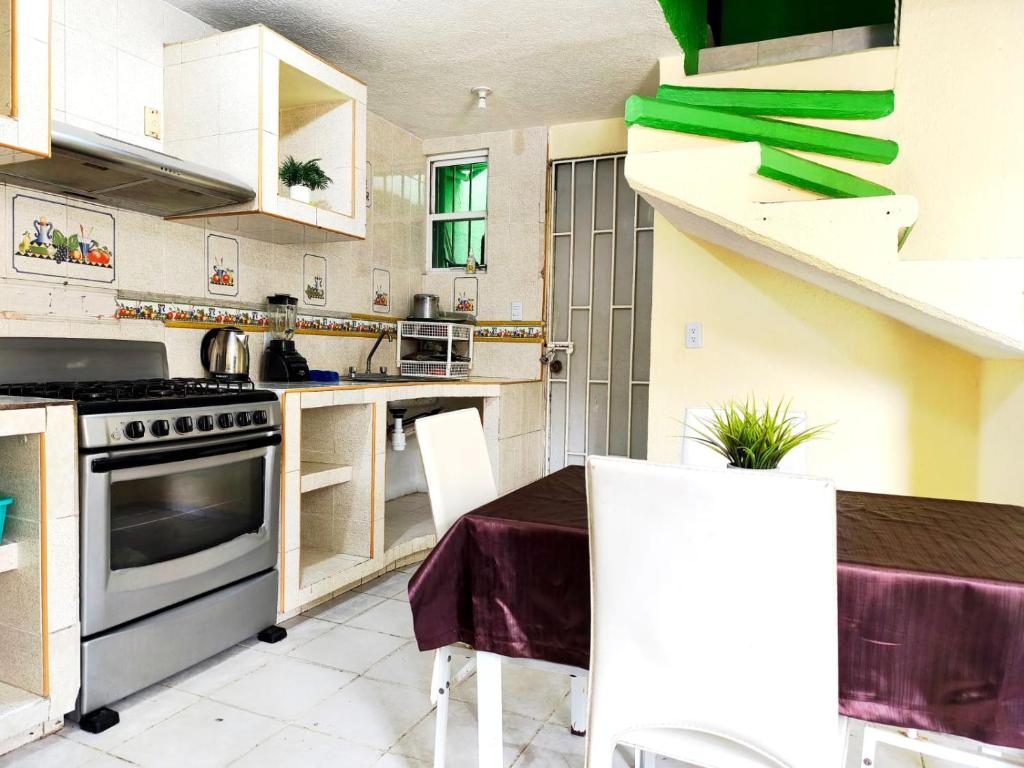 a kitchen with a table and a stove top oven at Casa confortable cerca de FORUM in Coatzacoalcos
