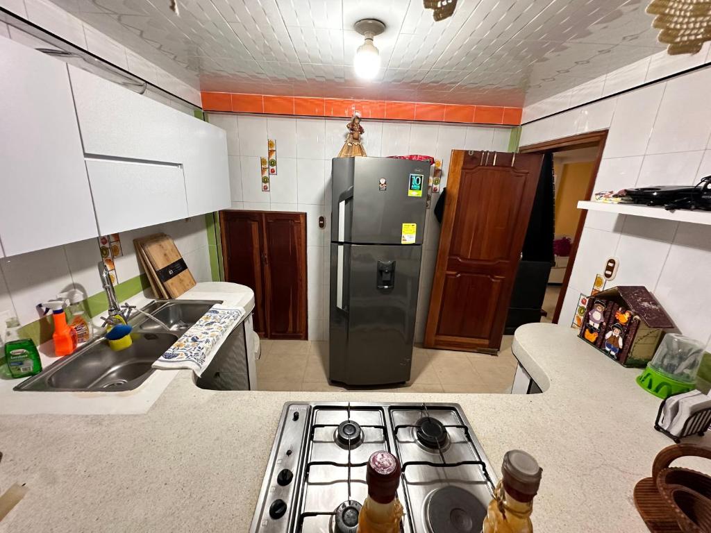 Una cocina con refrigerador y fregadero. en Habitación privada con terraza, en Quimbaya