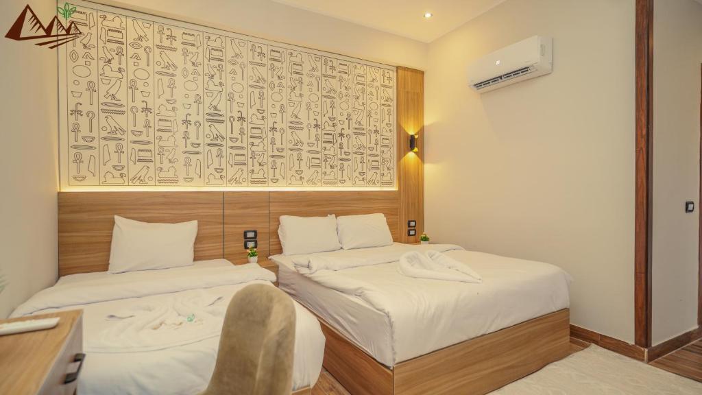 a hotel room with two beds and a chair at Global pyramids Inn in Cairo
