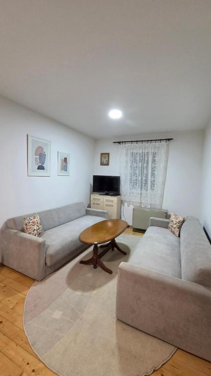 a living room with two couches and a table at Vikendica Miki 2 in Bratunac