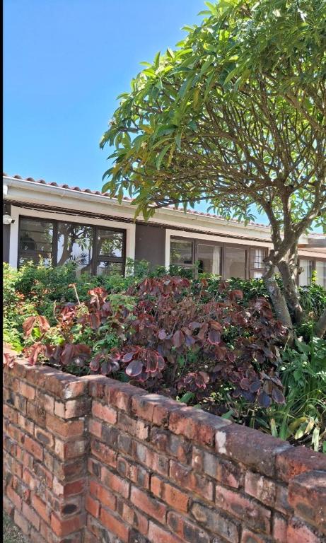 a brick retaining wall in front of a house at 106 Barracuda Self-catering in Geneva