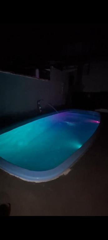 a blue bath tub sitting in a dark room at Casa em Ubatuba beach two in Ubatuba