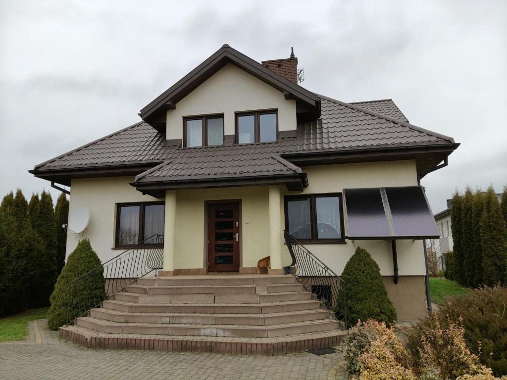 a white house with a black roof at Agroturystyka na Winnicy in Dys