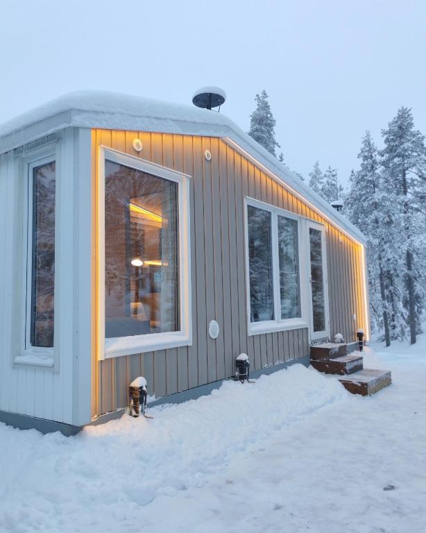 Villa Louhikko - Aavasaksa, Lapland في Aavasaksa: منزل صغير في الثلج مزود بصنبور إطفاء حريق