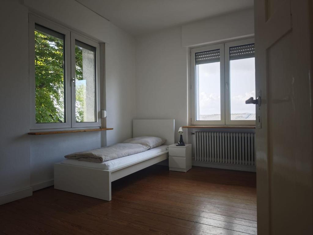 Habitación blanca con 1 cama y 2 ventanas en DUK42a, en Karlsruhe