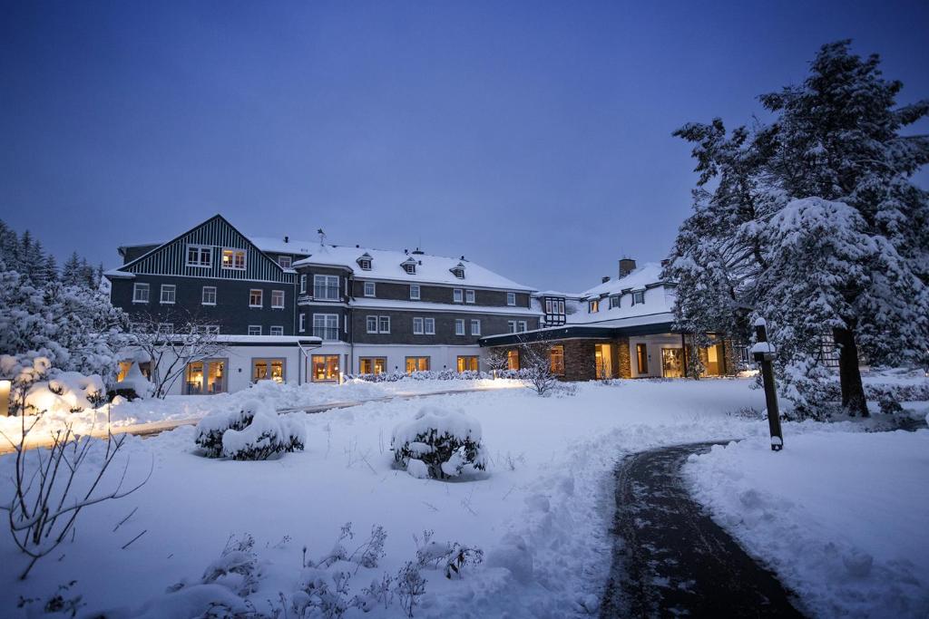 施马伦贝格佳德豪斯维泽酒店的一座大建筑,晚上被雪覆盖