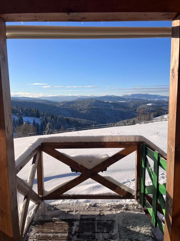a view of a snow covered mountain from a window at Tiny House Casuta Schiorului 2, Mărișel Apuseni in Mărişel
