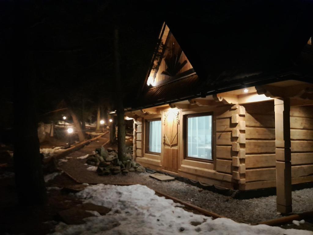 a log cabin in the snow at night at Domek GAWRA in Ząb