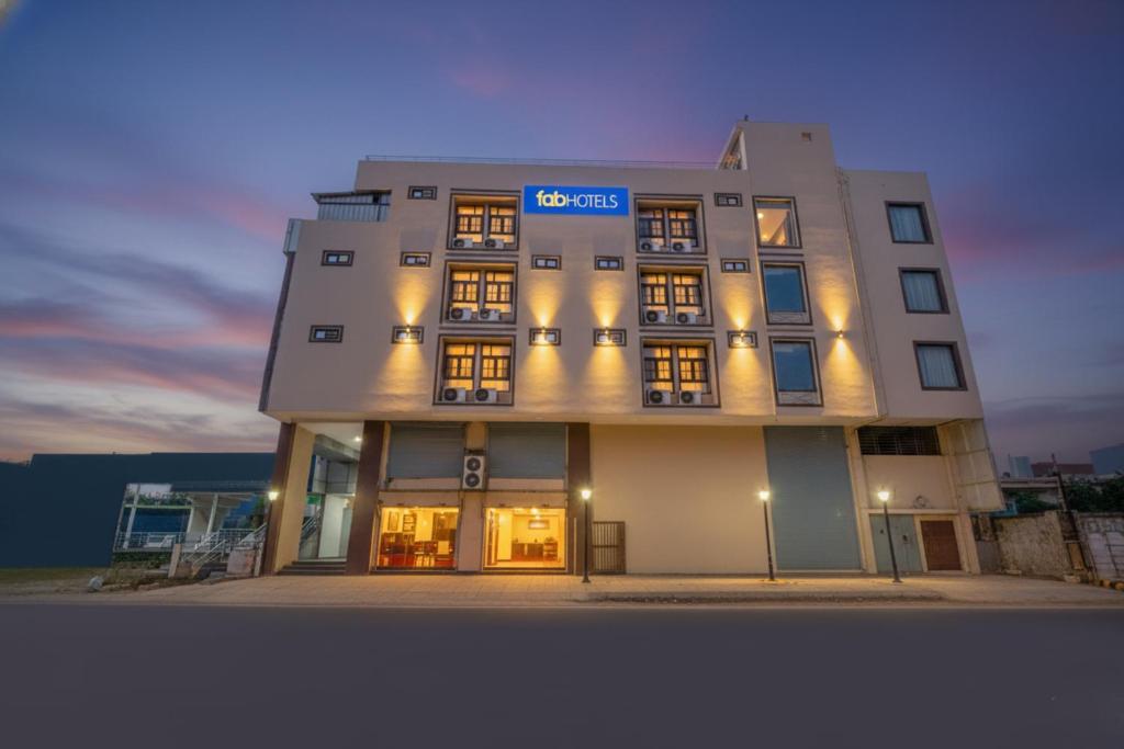 a tall building with a sign on it at night at FabHotel Family Inn in Lucknow