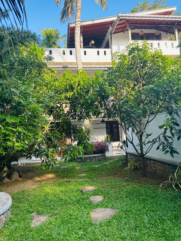a house with a garden in front of it at Oshi villa in Unawatuna