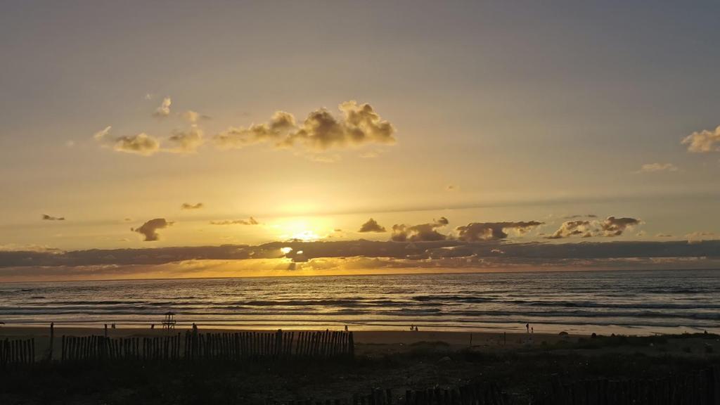 een zonsondergang op het strand met de oceaan bij La Perle Aïn Diab Beachfront in Casablanca