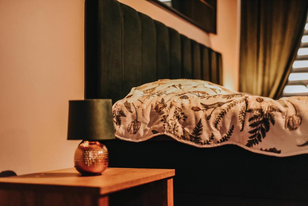 a bedroom with a bed and a table with a lamp at Apartament Hallera in Chełmno