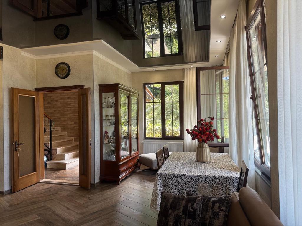 Villa Kolkhi في كفارياتي: غرفة كبيرة مع طاولة وبعض النوافذ