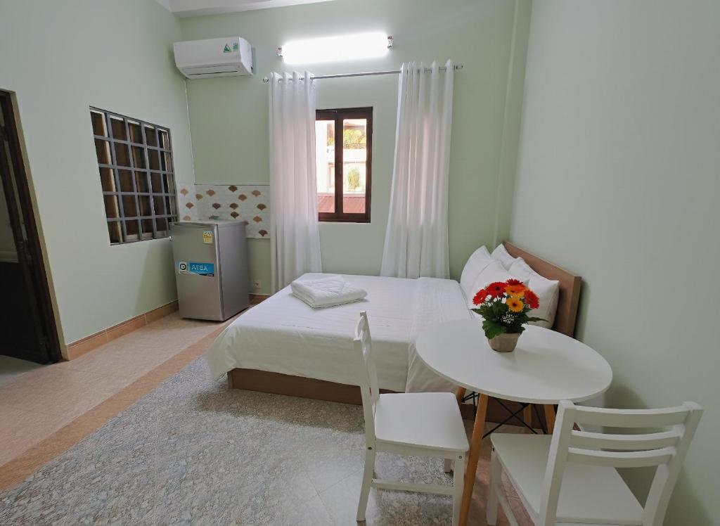 een slaapkamer met een bed en een tafel en stoelen bij Lux saigon airport in Ho Chi Minh-stad