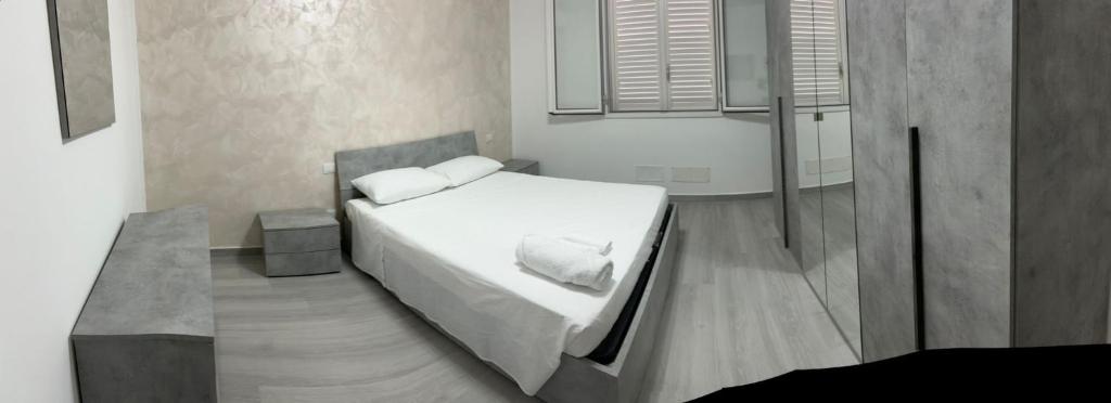 a bedroom with a bed with white sheets and pillows at BALISTRERI HOUSe in Trabia