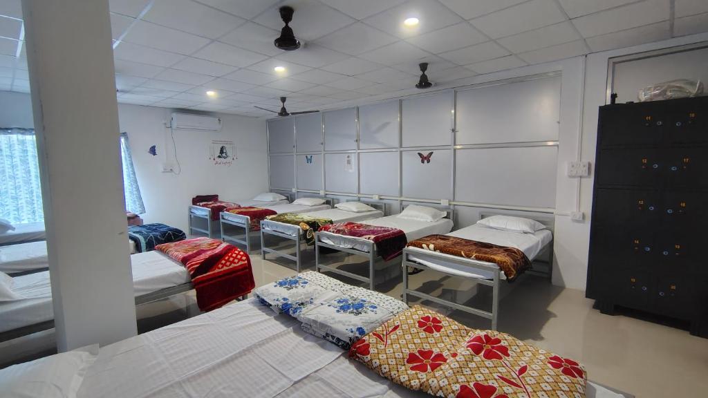 a room with a bunch of beds in it at Maa Tarini AC Dormitory in Balasore