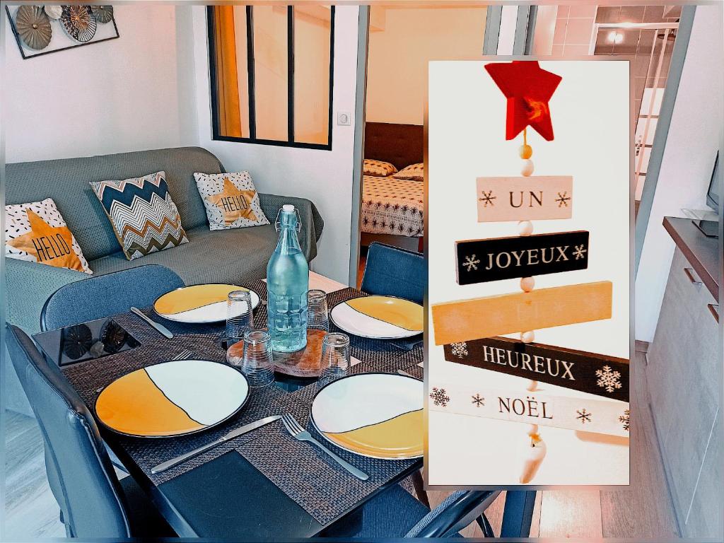 a dining room table with plates and a couch at Les Apparts du Vignal de Cheyrac in Polignac