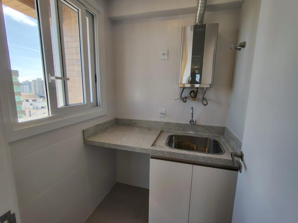 a bathroom with a sink and a window at Praia e mar in Tramandaí