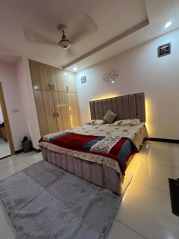 ein Schlafzimmer mit einem großen Bett in einem Zimmer in der Unterkunft Syed Apartment 302 in Islamabad