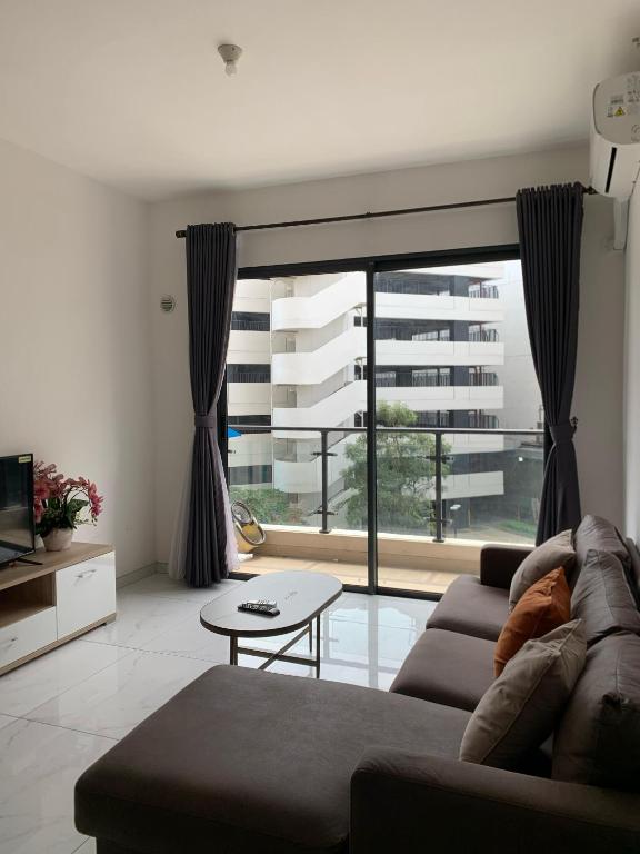 a living room with a couch and a large window at Sky House BSD D2-3A - 3 Bedroom Type in Samporo