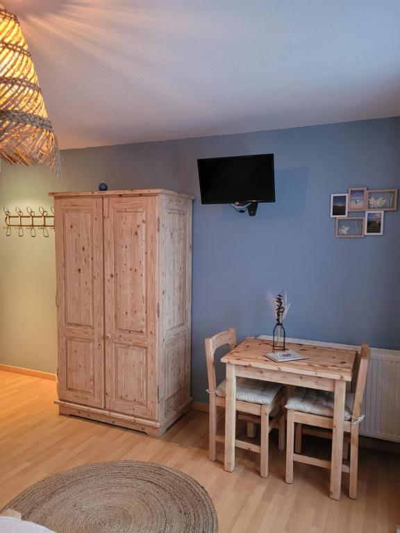 a dining room with a table and a tv on a wall at LA MAISON Crêperie-Bar-Hôtel in Le Valtin