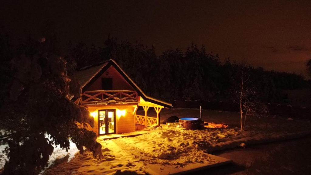 Łowisko Źródła Chatka Zimorodka : كابينة خشب مضاءة بالثلج ليلا