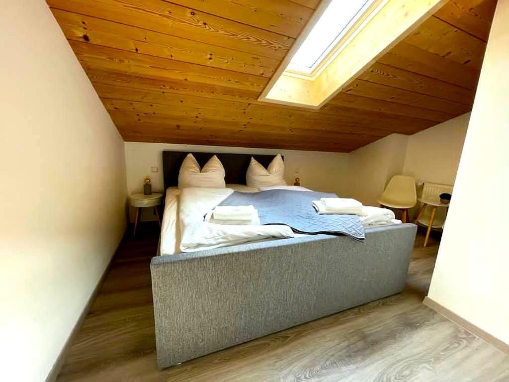 a bedroom with a large bed with a wooden ceiling at Gemütliche Ferienwohnung im DG am Tegernsee - Bergblick, Ruhe & ganz viel Platz in Bad Wiessee