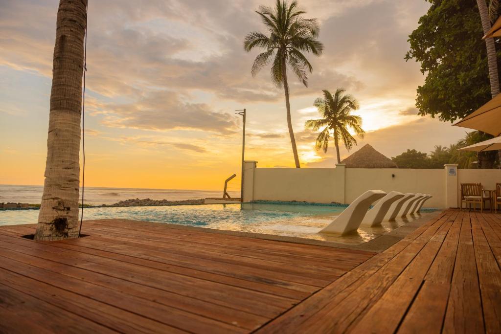 Una piscina con terraza de madera y vistas al mar. en The rooftop Beach & club, en La Libertad