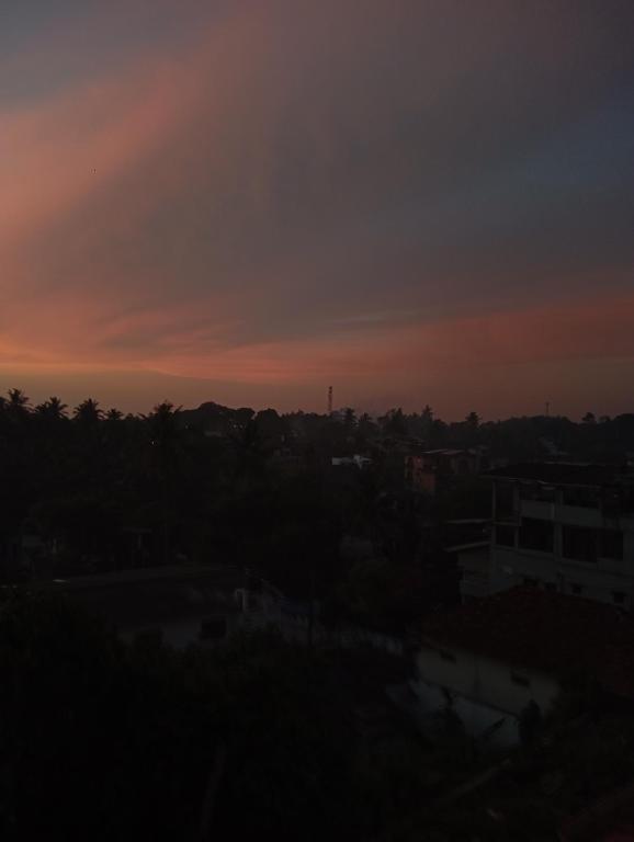 een zonsondergang boven een stad met bomen en gebouwen bij Villa SeaLoom in Galle
