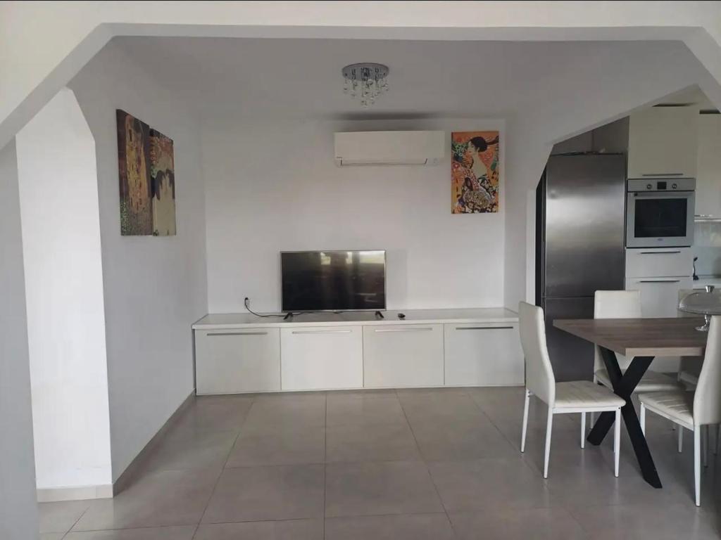 a kitchen with a table and a stainless steel refrigerator at Mare Resort Maggana in Xanthi