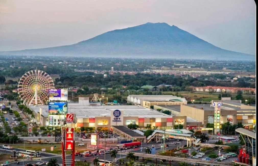 New Studio Boho Studio with PS4 & Balcony في سان فيرناندو: مدينة بها عجلة دوارة وجبل في الخلفية