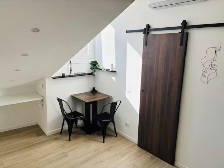 a room with a table and chairs and a door at Urban Nest in Milan