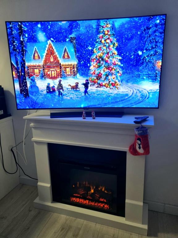 a flat screen tv sitting on top of a fireplace at La Matei in Bistriţa