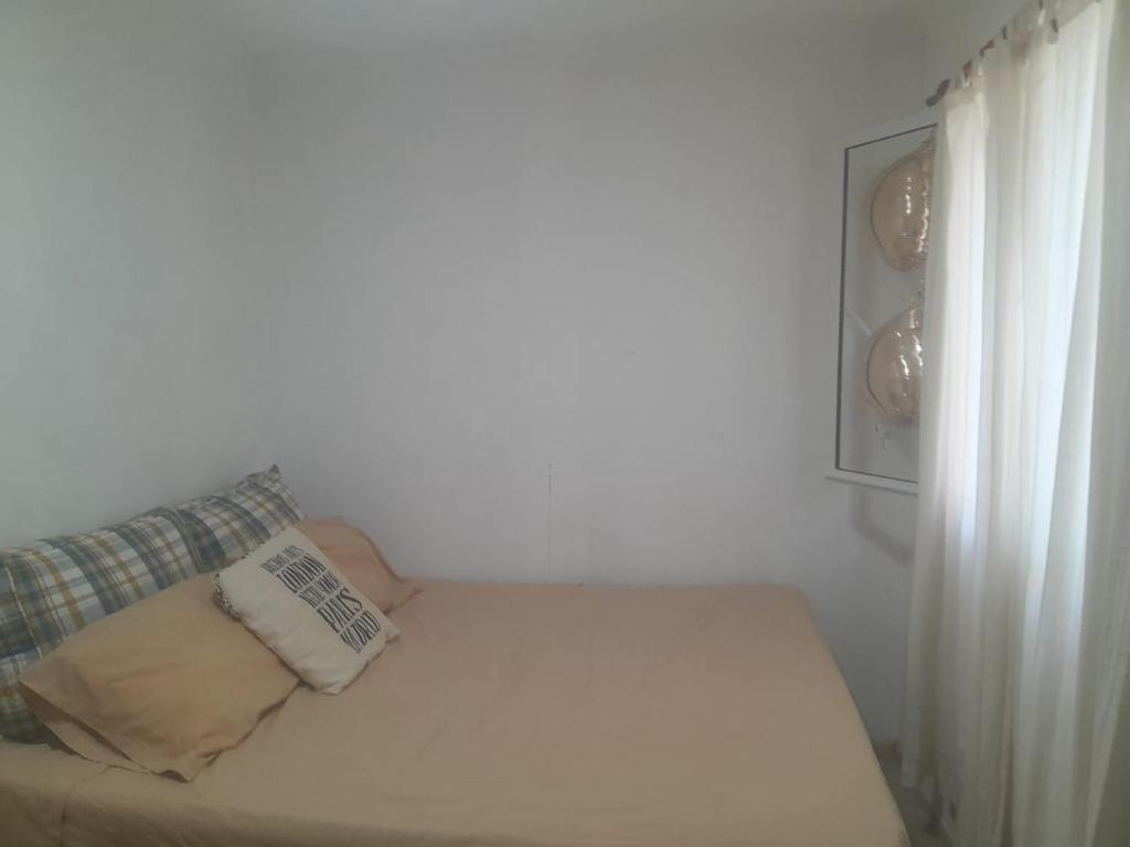 een witte kamer met een bank en een raam bij Viento Sur in Estancia El Polomo