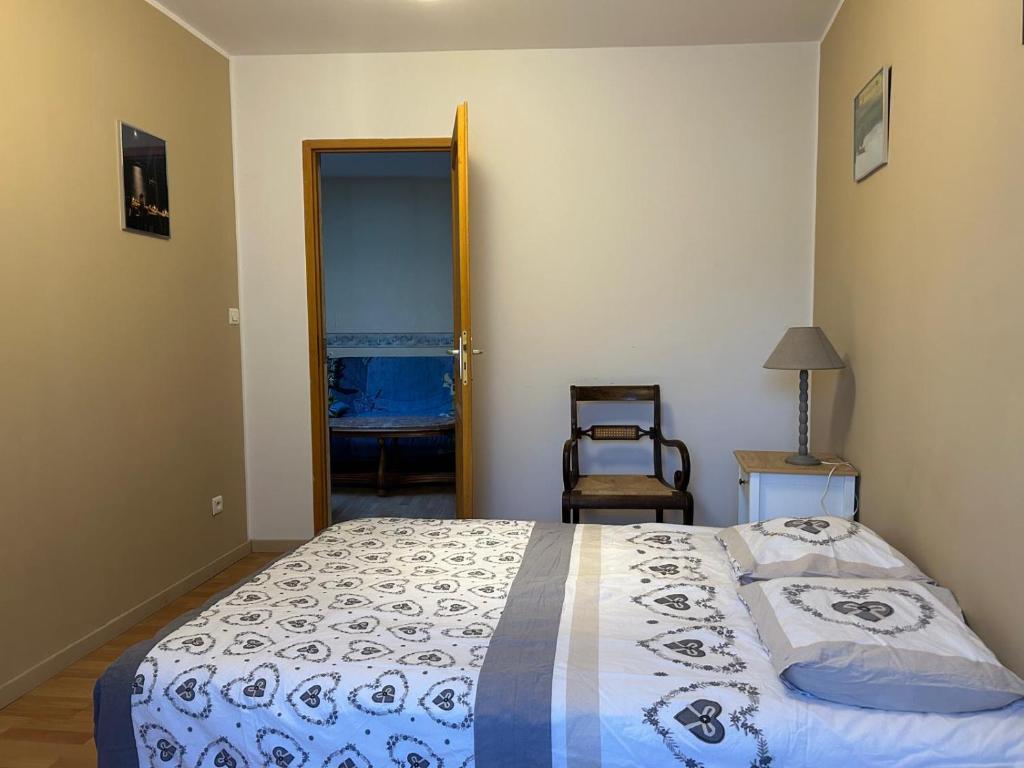 een slaapkamer met een bed en een stoel erin bij 2 Chambres dans maison typique in Beaumont-lès-Valence