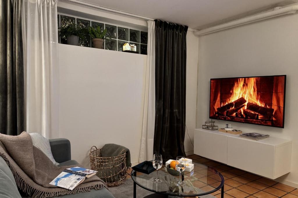 a living room with a couch and a fireplace at Sundsvall By M - Basement Studio in Sundsvall