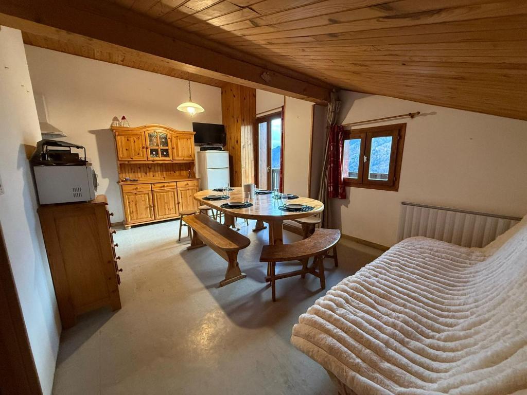 a bedroom with a table and a bed in a room at Appartement 5 pers - Draps et serviettes inclus in La Lechere