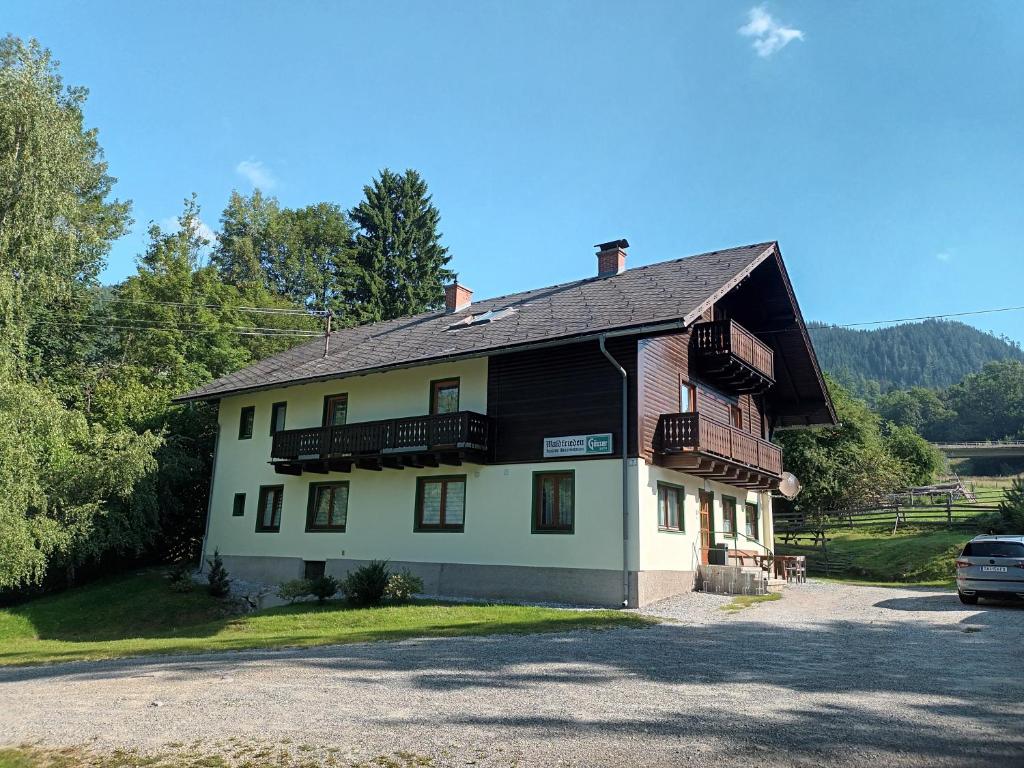 Pension Waldfrieden في Steinhaus am Semmering: منزل أبيض وأسود مع موقف للسيارات