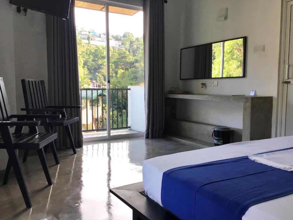 a bedroom with a bed and a view of a balcony at Everdew Kandy Rooms in Kandy