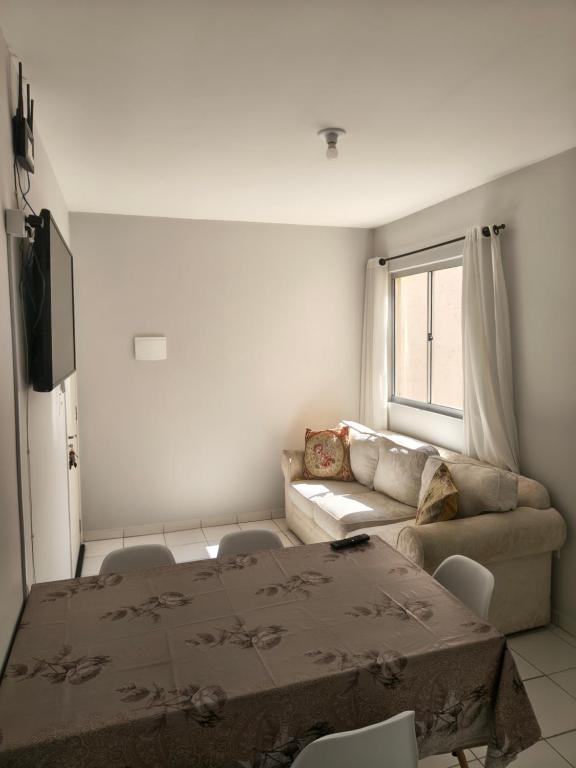 uma sala de estar com um sofá e uma mesa em Apartamento aconchegante próximo a várias praias! em Palhoça