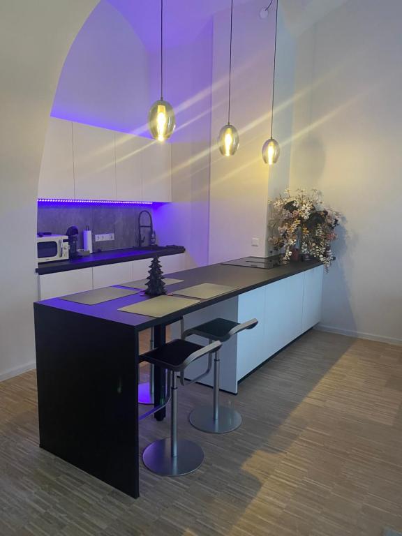 Una cocina con una isla en blanco y negro con taburetes. en Salinenblick, en Bad Reichenhall