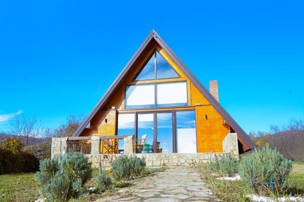 Casa con techo de paja y ventanas grandes en Kosmaj Escape, en Koraćica