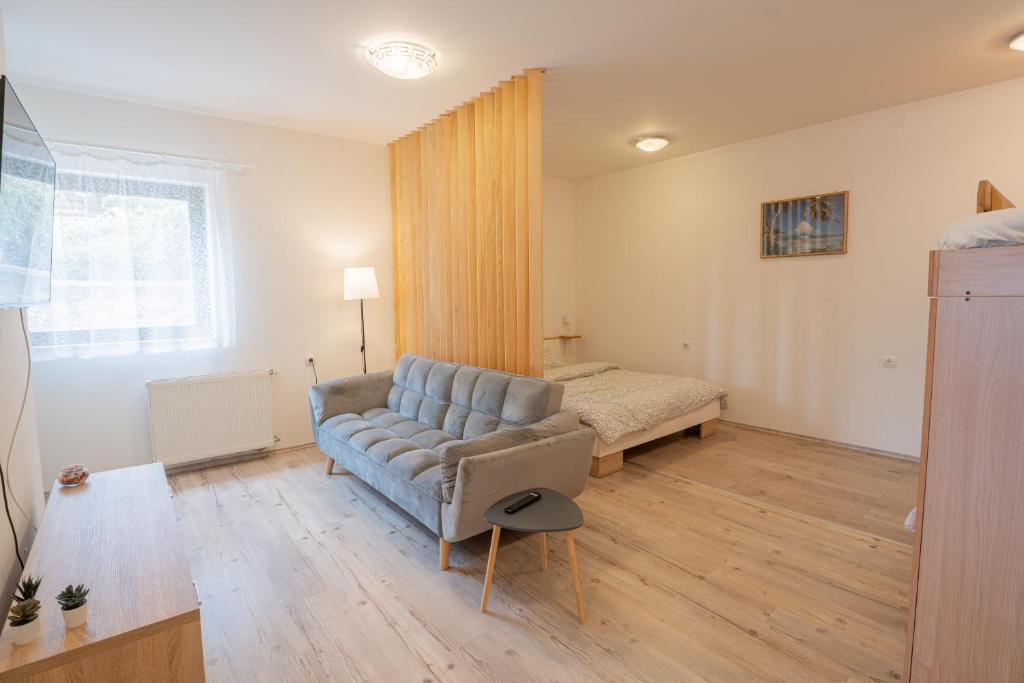 a living room with a couch and a bed at Studio apartman LuG in Ravna Gora