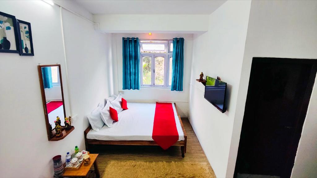 a small bedroom with a bed with red pillows at Jo'stel Hotel Winter Green- MG Marg in Gangtok