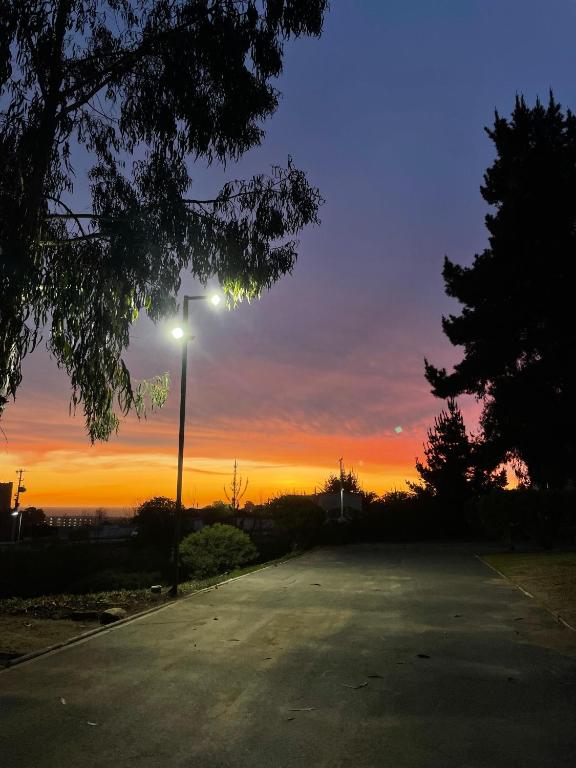 an empty street with a street light at sunset at Departamento en el Tabo in El Tabo