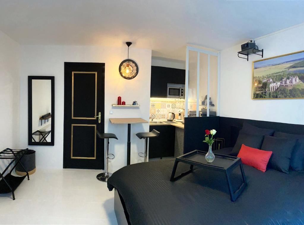 a living room with a bed and a table in it at La Suite Nocturne in Fère-en-Tardenois